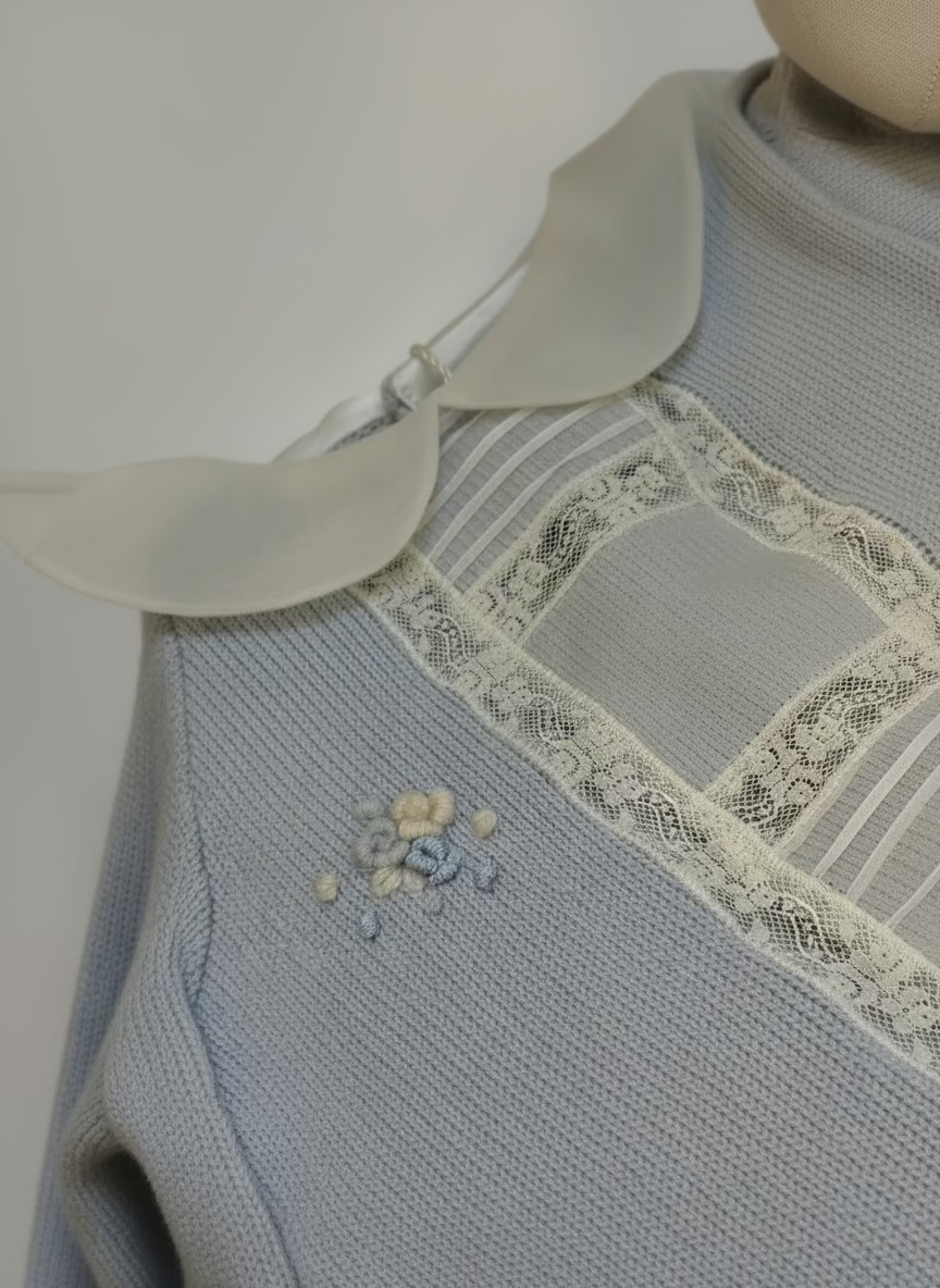 Light blue knitted garment with lace trim on a mannequin