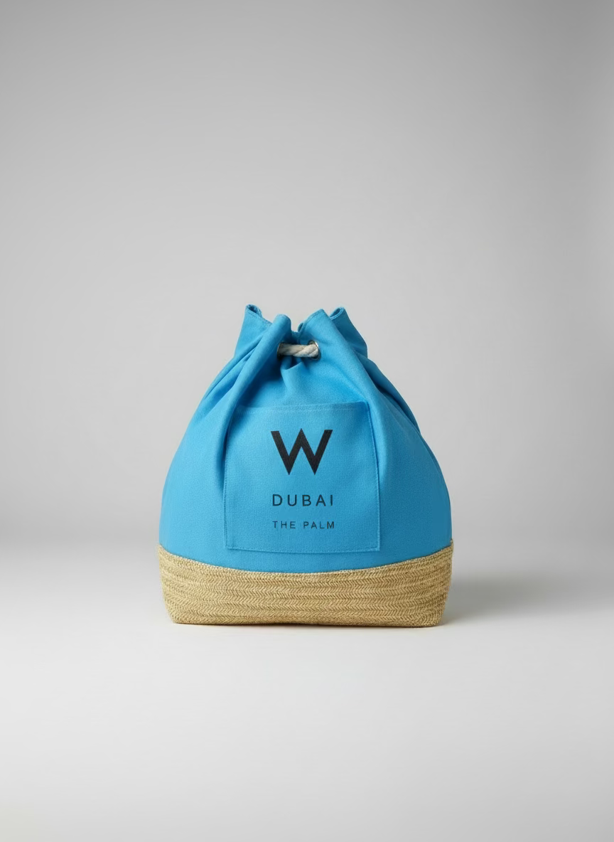 Blue drawstring bag with 'Dubai The Palm' branding on a wooden surface.