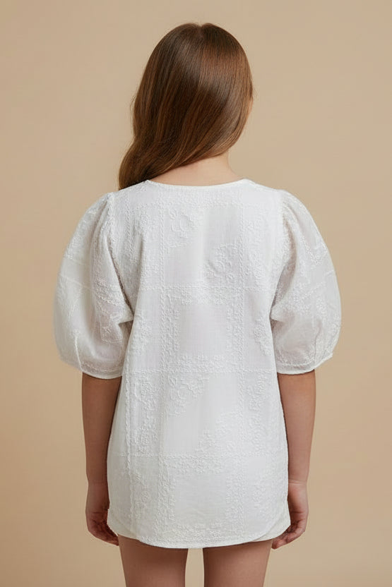 White lace top on a beige tiled floor