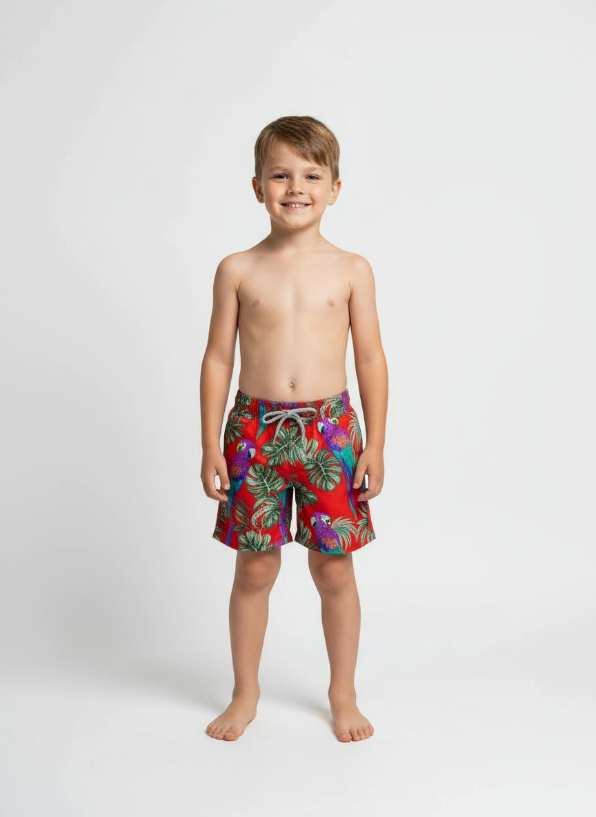 Colorful swim shorts with parrot and leaf pattern on a red background