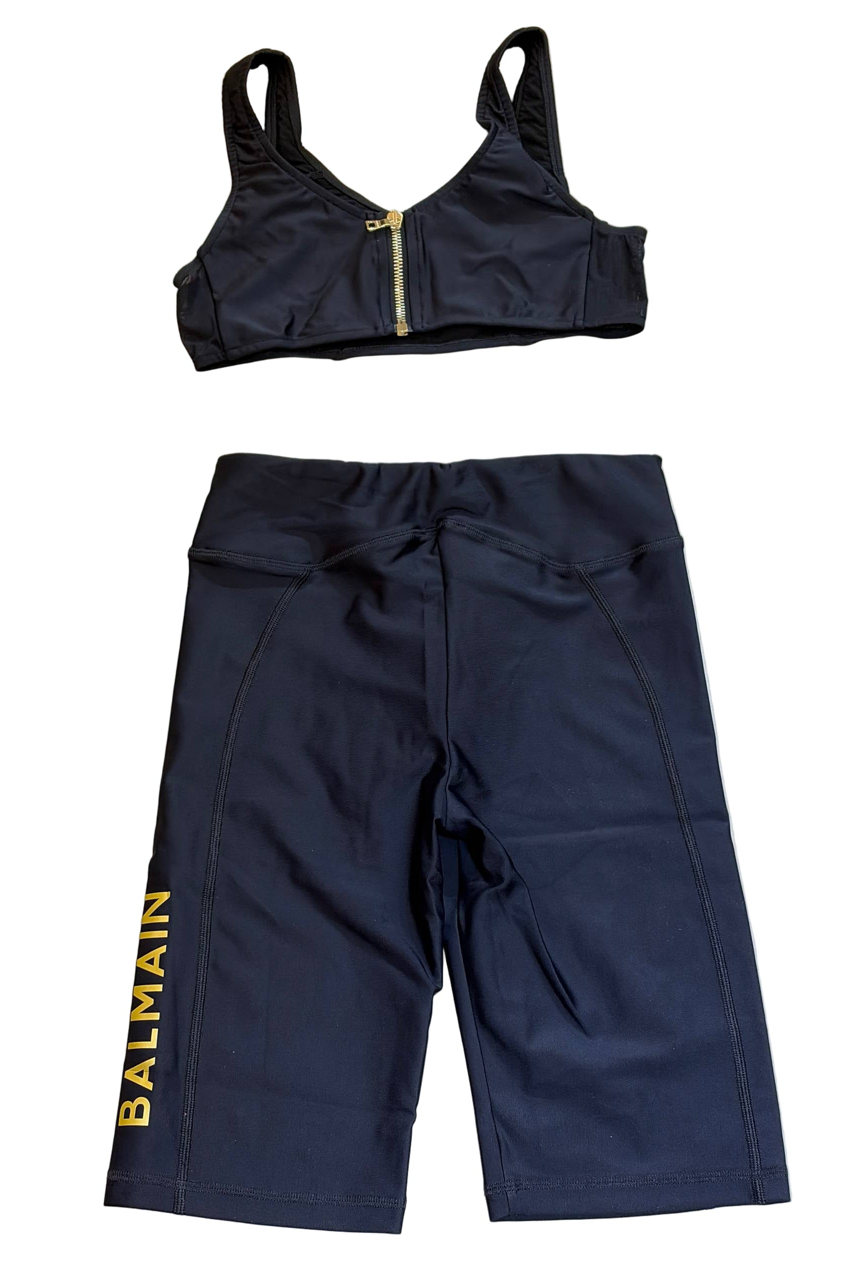 Black sports bra and shorts set with 'Balmain' branding on a light background