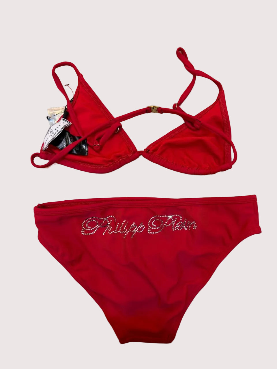 Red Philipp Plein bikini set on a beige background