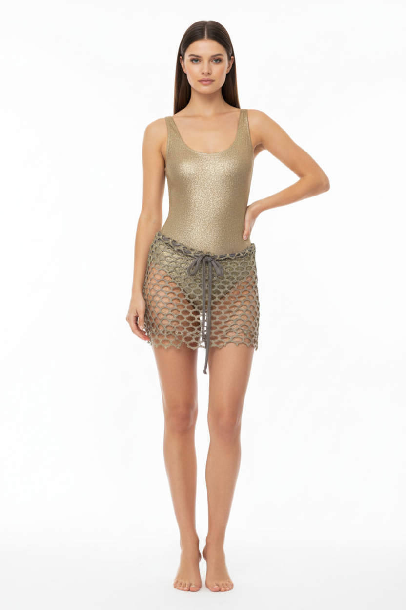 Woman wearing a gold bodysuit with a matching fishnet skirt on a white background